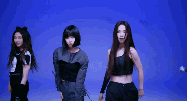 a group of young women are dancing together in front of a blue background