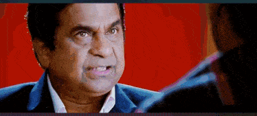 a man in a suit and white shirt is talking to another man .