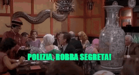 a group of people are sitting at a table with the words ' polizei robba segreta ' written in green