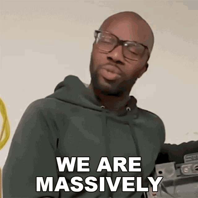 a man wearing glasses and a hoodie says we are massively
