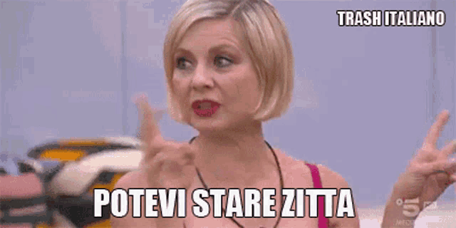 a woman holds her finger to her nose and says " potevi stare zitta "