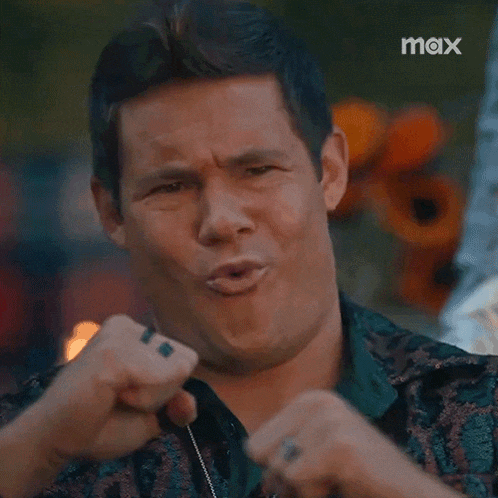 a man is making a funny face while holding his fist up .