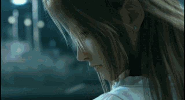 a close up of a woman 's face with long hair looking down at something .