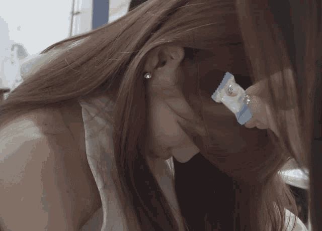 a close up of a woman eating a candy