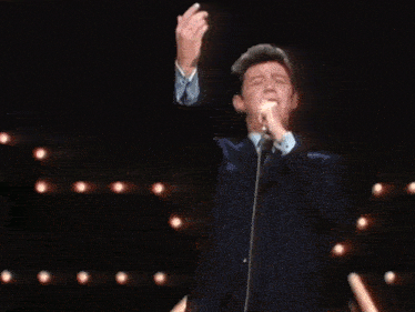 a man in a suit and tie has his arms outstretched