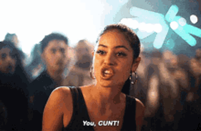 a woman in a black tank top says you cunt in front of a crowd of people .