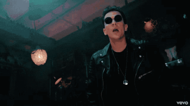 a man wearing sunglasses and a leather jacket has the word vevo on the bottom