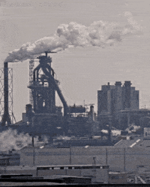 a factory with smoke coming out of the chimneys and the time displayed on the bottom of the screen
