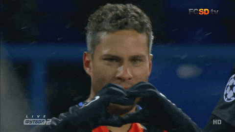 a man making a heart shape with his hands in front of a screen that says fcsdv