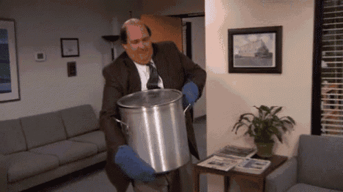 a man in a suit and tie is holding a large pot in a waiting room