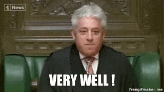 a man in a suit and tie is sitting in a chair with the words `` very well '' written on his face .