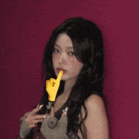 a woman is holding a pair of scissors in front of her face