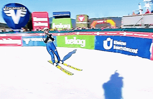 a skier is jumping over a fence that says kelag