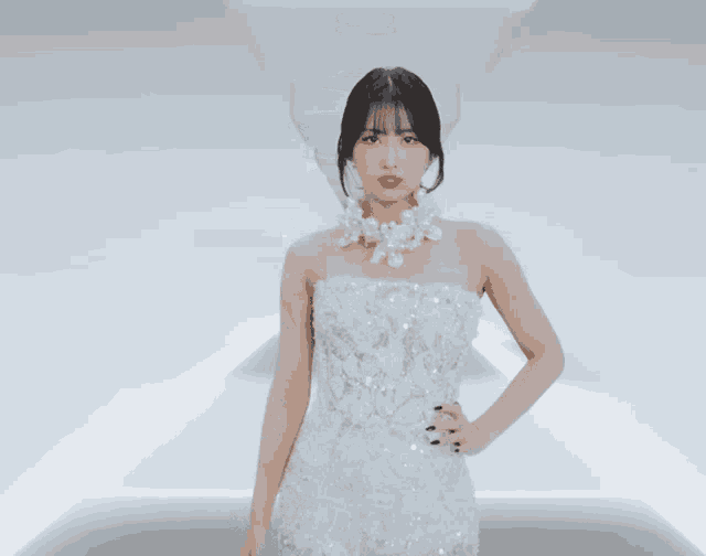 a woman wearing a white dress and a pearl necklace