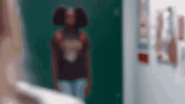 a blurry picture of a woman standing in front of a door .