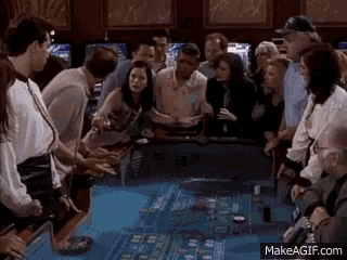 a group of people are playing a game of roulette at a casino .