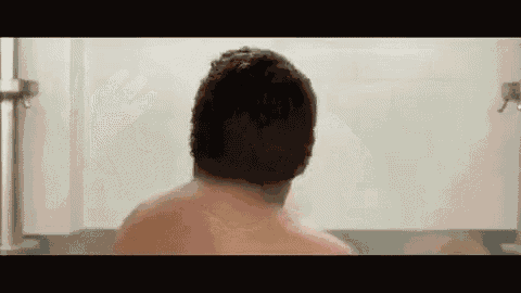 a man is taking a bath in a bathtub with a towel around his head .