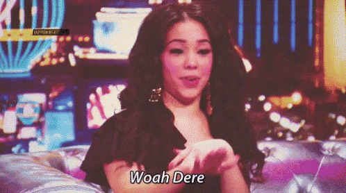 a woman is sitting on a couch and says woah dere on the screen