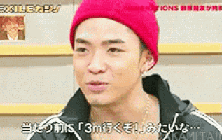 a young man wearing a red beanie and a black jacket