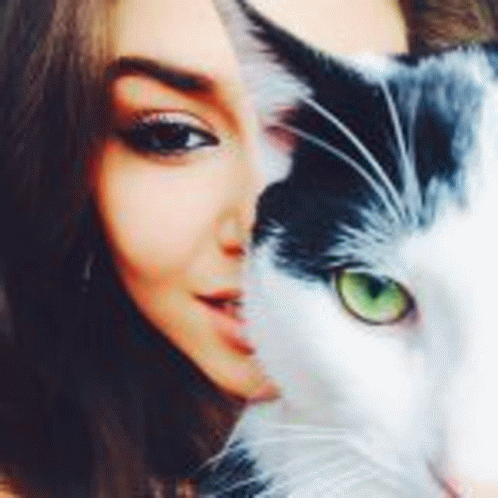 a woman is taking a selfie with half of her face covered by a black and white cat .