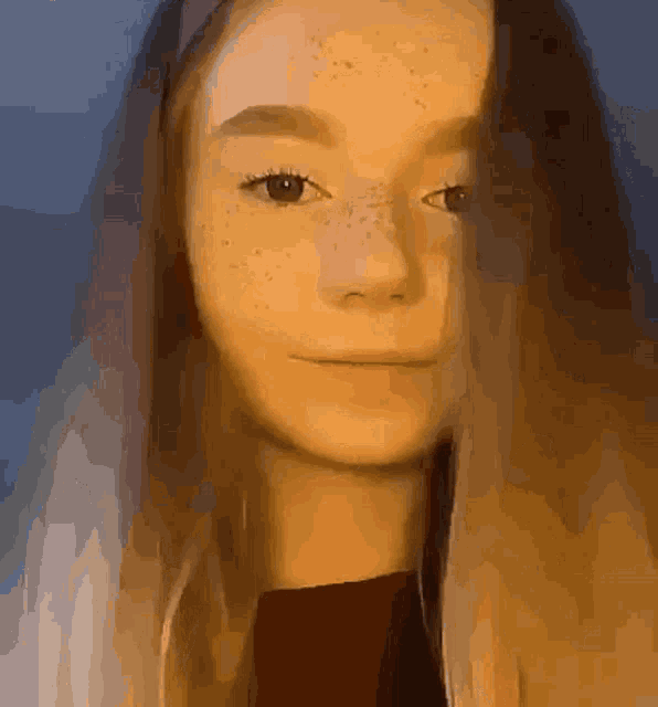 a girl with long hair and freckles on her face