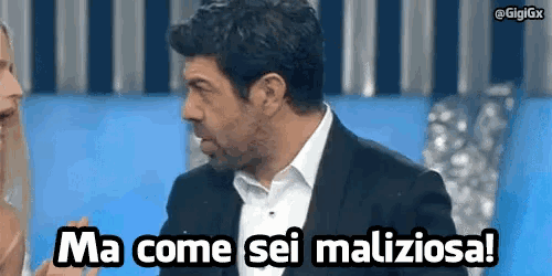 a man in a suit is talking to a woman and says ma come sei maliciosa