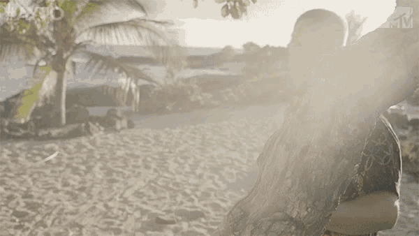 a man standing on a beach with the word santo on the bottom left