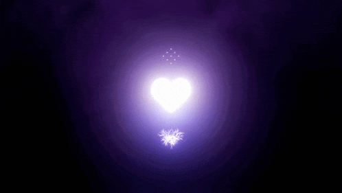 a purple heart is surrounded by smaller hearts in a dark room