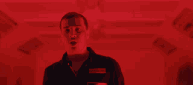 a man flexes his muscles in a red background