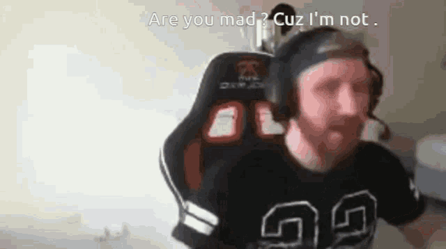 a man wearing headphones and a black shirt with the number 69 on it says are you mad cuz i 'm not