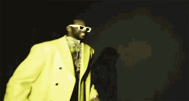 a man in a yellow jacket and white sunglasses