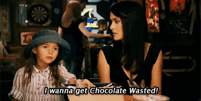a woman and a little girl are sitting at a table and the little girl is saying i wanna get chocolate wasted