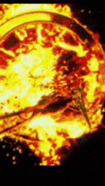 a close up of a fire with a clock in the background