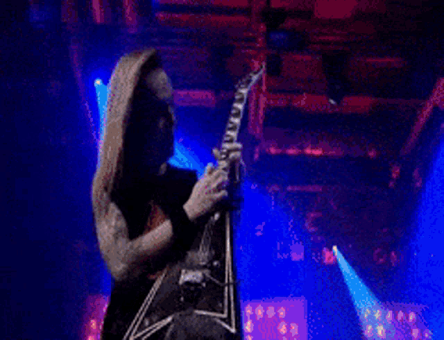 a man is playing a guitar on a stage