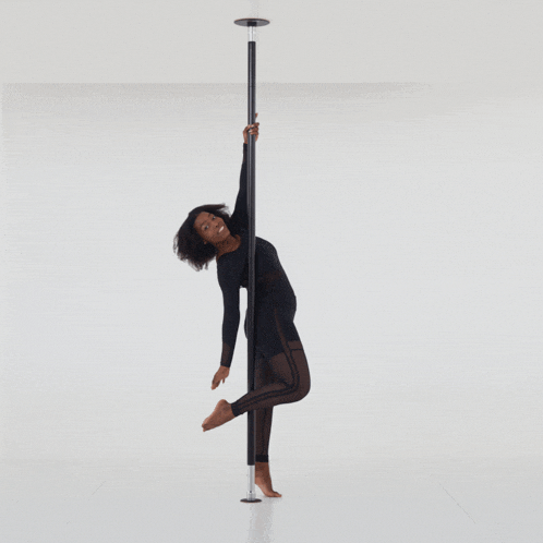 a woman is standing on a pole in a room