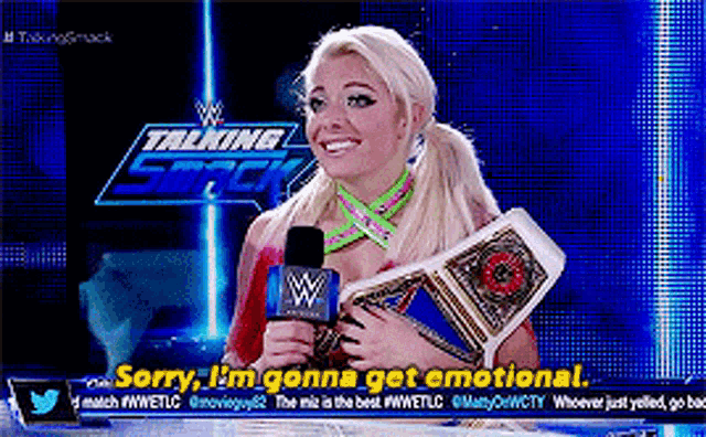 a woman is holding a wrestling championship belt and talking into a microphone on a talking smack show