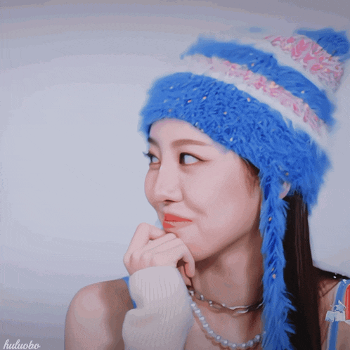 a woman wearing a blue and white hat has the word huluobo on the bottom