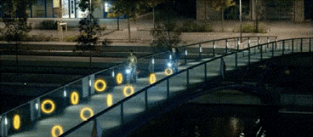 a bridge is lit up at night and has circles on it