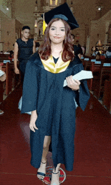 a woman wearing a graduation cap and gown stands in a church