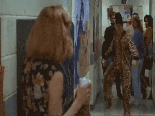 a man in a leopard print outfit is standing next to a woman in a floral dress .