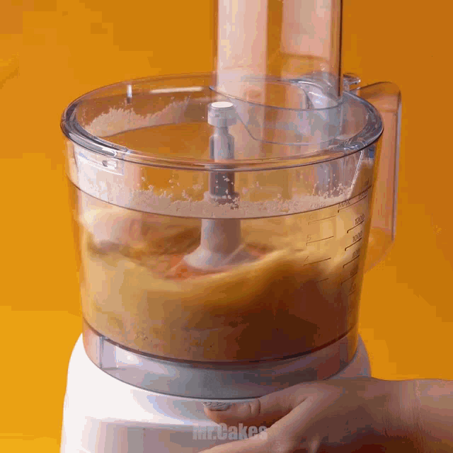 a person is using a food processor with the words mr. cakes written on the bottom