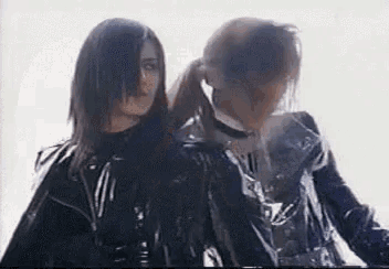 a couple of women are standing next to each other in a room .