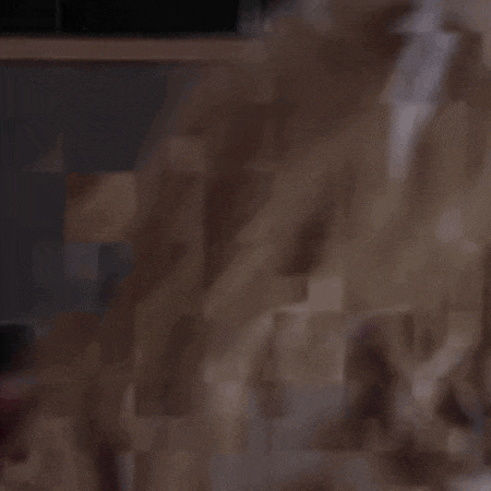 a blurry picture of a person sitting in front of a pile of straw .