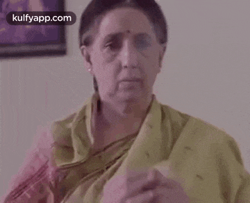 a woman is praying with her hands folded in prayer .