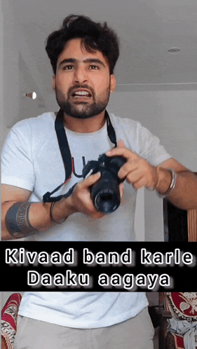 a man in a white shirt is holding a camera with the caption kiwaad band karle daaku aagaya