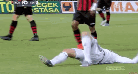 a soccer player is laying on the ground with his head down