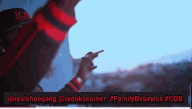 a man in a red and black sweater is pointing at something