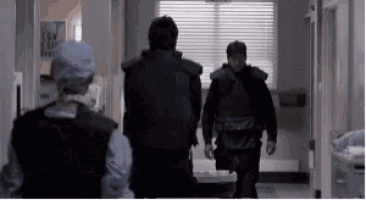 a group of people are walking down a hallway .