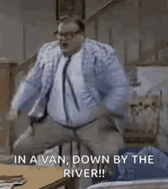 a man in a suit and tie is dancing in a living room .