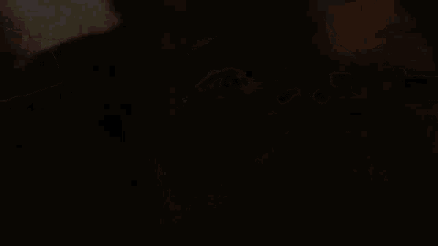 a close up of a person 's face in the dark making a scary face .